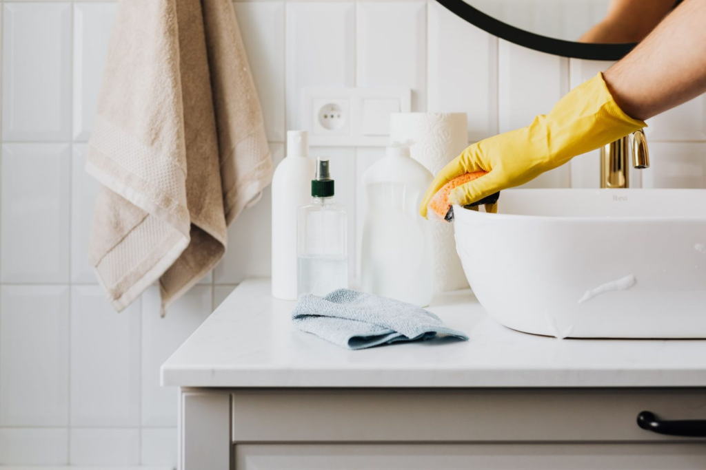 Wastafel wordt schoongemaakt met handschoenen
